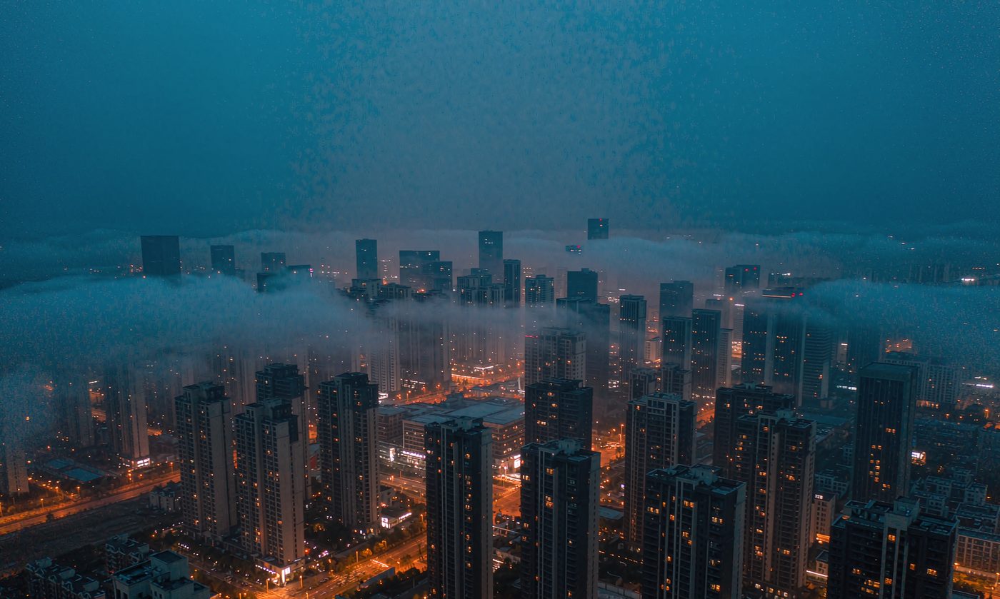 城市蓝调时刻的天际线，暖色灯火与低雾